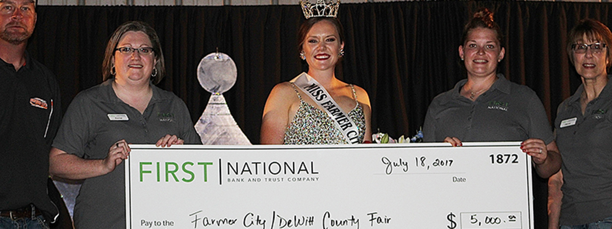 fair queen and fnbt employees holding giant check