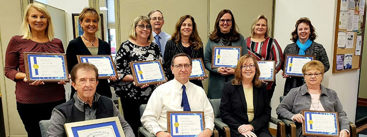 10 bank employees with award certificates 