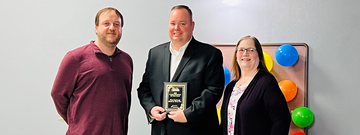 First National Bank employee accepts award from Clinton