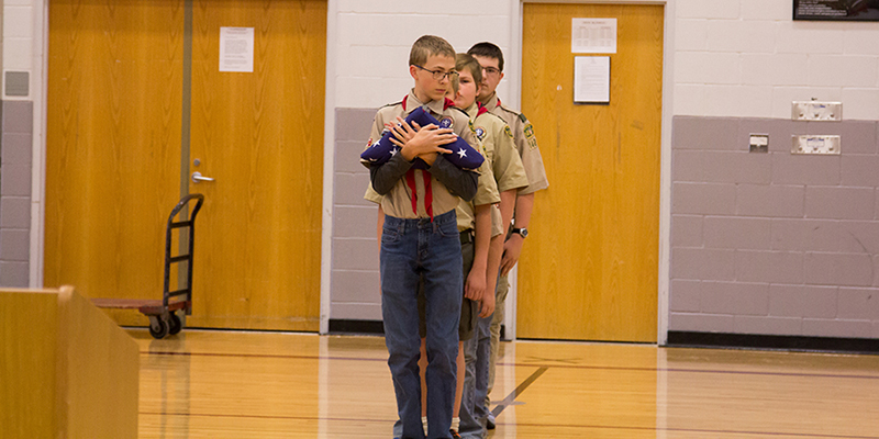 school age boys carrying in the american flag